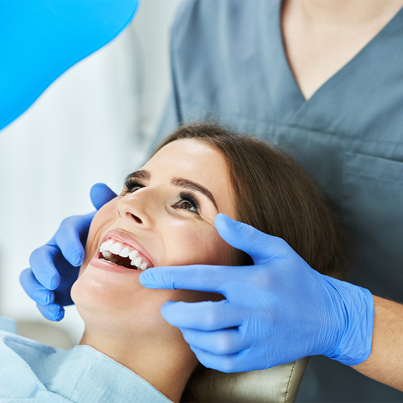 Detalle de la aplicación de gel blanqueador y protector gingival en clínica dental.