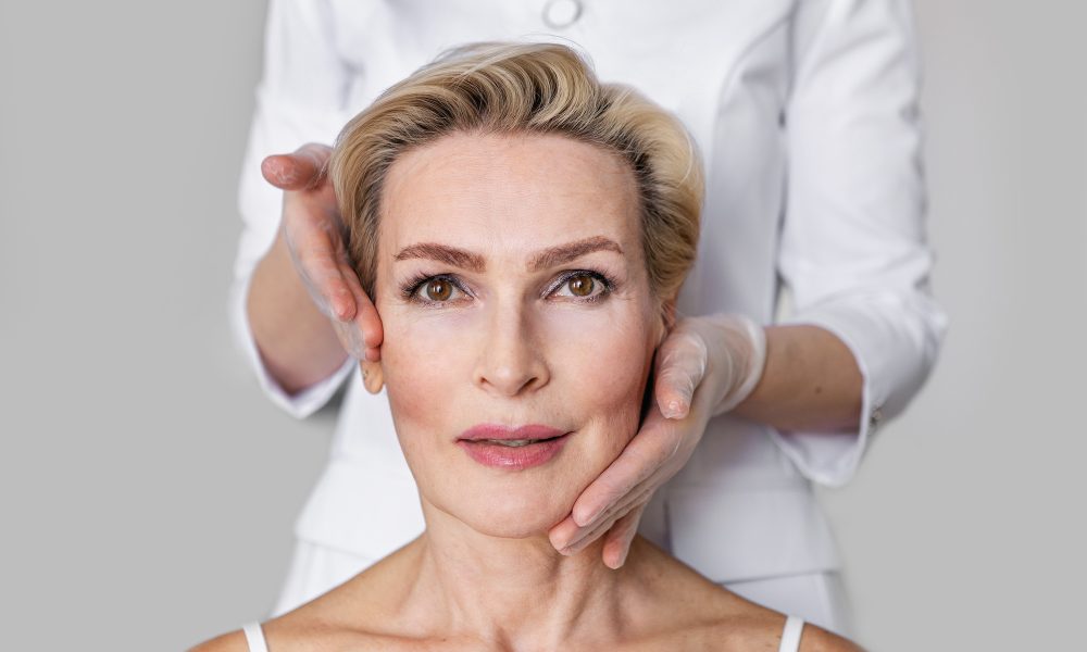 Elegant senior woman with short blonde hair and brown eyes during facial care procedure. Cosmetologist hands touching her face. Beauty clinic and anti-aging skincare. Portrait of mature model SSUCv3H4sIAAAAAAAACpxTy47bMAy8F+g/BDrXgF6O7f5K0QNtKbGwshVI8ra7Qf699ENeOd1eehOHFGdIje5fv5xOpIVgOvL9dJ8jjI21U4geonEjwvTbhns9Ku1z5NWLM80BMHmklYnOG7A52ELs+hEGjeA4WTvDjyVJQoQ4BR0yLaBcq0N03QuCLPUI/RSj9n/hYGF4ywHlNQwhmoVNJJRx4S85cDO/I8xAJqaDqK+o/iAnrerHGp9SYkniDUwRsnVdlU7tgiVobf5fN9fDz33Wqx67edj7I1PttdWwrnDTSJSUtWzgUkimeSG7RhbNWdNClrUsZSvbFi4Ly9qavPzC1Q7L1FtTmJRx2RZeXQc2PO0LzA08HO7dvOnMeM0QF/vFQalT56Yx+rd8eGKdu0Fr5xe7II1OeA8hYLlKeP5W6Fc3ZDyji8sOtq5E4WPOIROScsEqLkrWsIrKmuTW6w32WeQkgdPNOlB6Jt0f7MmUVVnVkjORTPeJP1MJ/yjZrbrlyvRBnl27F5QfBcnAW47TrHHycsqVdE0l583GGgzKO850vCZEWf2LTkiePs7nWoU8nzfOw+fGZRiV/6bEiQQoFJVWuwkSJYFxhPf3fnrBdEMpZXKvOVATSVFzIwVdvLyRmnlIUjOhOL2IArTGb8B1XUDLaMGVbqGBs6yaDm89/gAAAP//AwD45nkSDwUAAA==